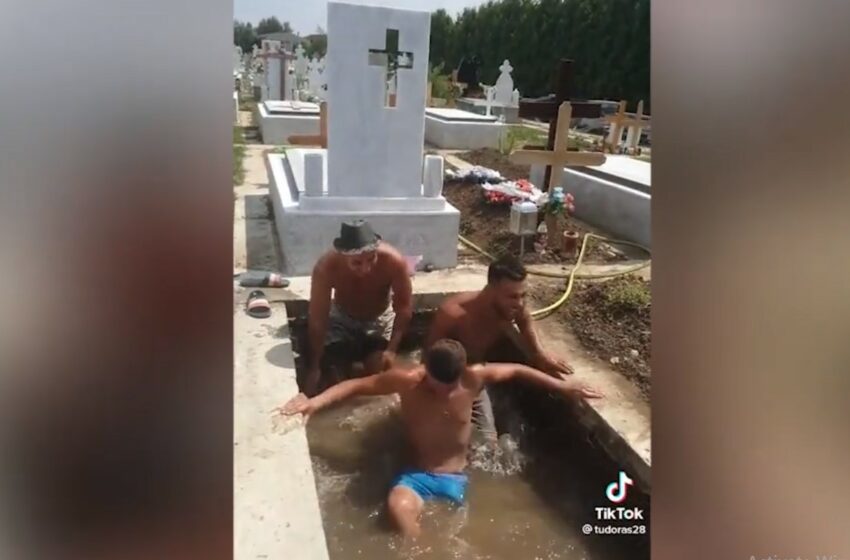  (video) Cavou transformat în piscină. Trei gropari s-au filmat pe TikTok în timp ce se răcoresc în cimitir