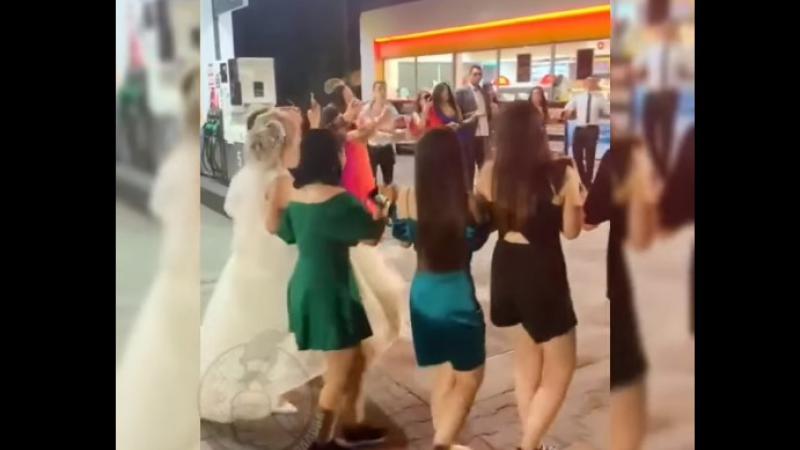 (video) Au încins o horă chiar la benzinărie: Nuntași, cu tot cu mire și mireasă, surprinși cum dansează la o stație PECO, unde au oprit să facă plinul