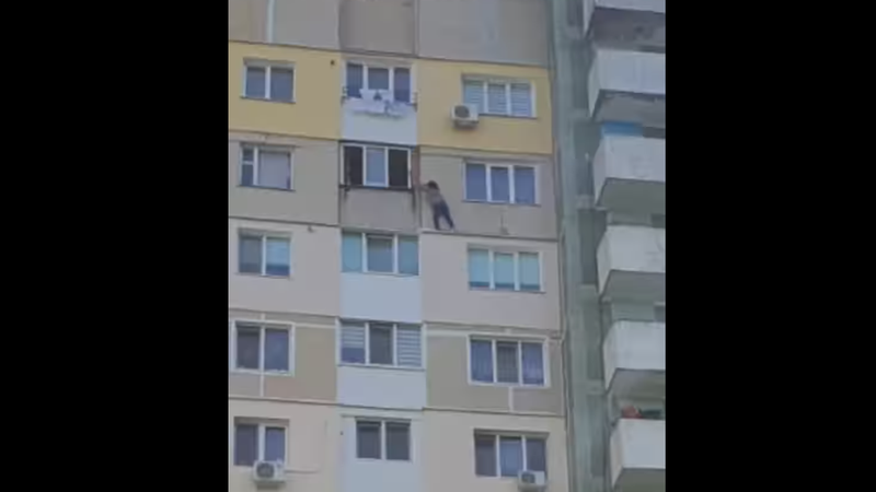  (VIDEO) O femeie surprinsă cum stă agățată de un geam, la etajul 12: Ce spun oamenii legii