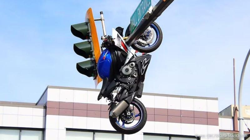 (video) Accident dramatic în Canada: O motocicletă a rămas suspendată de un semafor, după ce s-a izbit de o mașină și a zburat deasupra ei